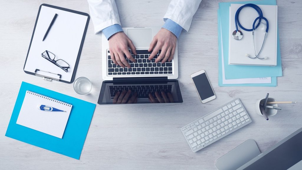 Medical billing and coding specialist working on a computer in a doctors office.