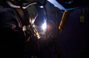 combination welding student welding with welding helmet on