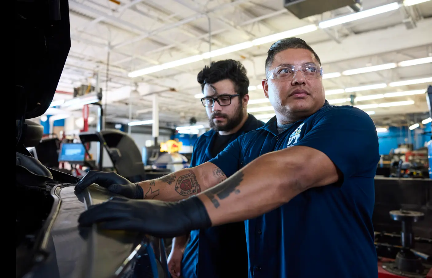 two stvt male students in a mechanic garage