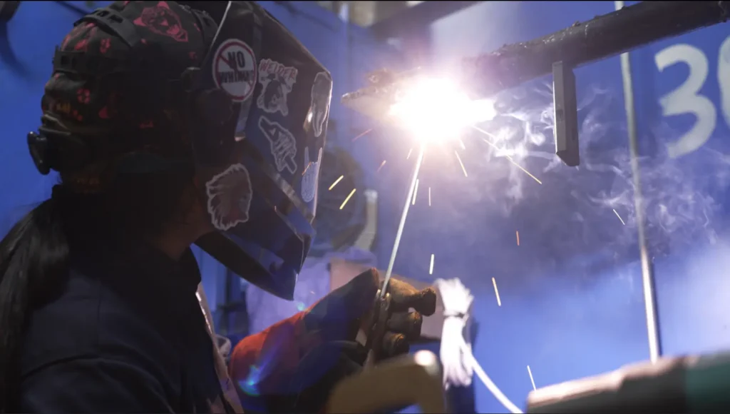 female welder welding with welding helmet